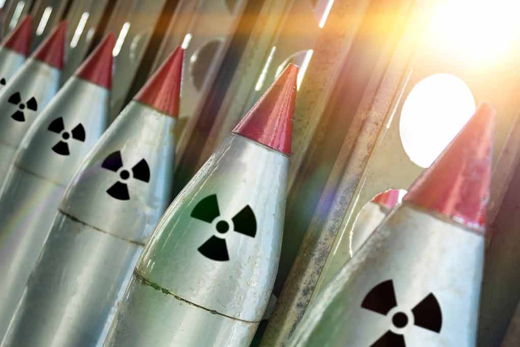 Nuclear missiles with radiation warning symbols lined up.