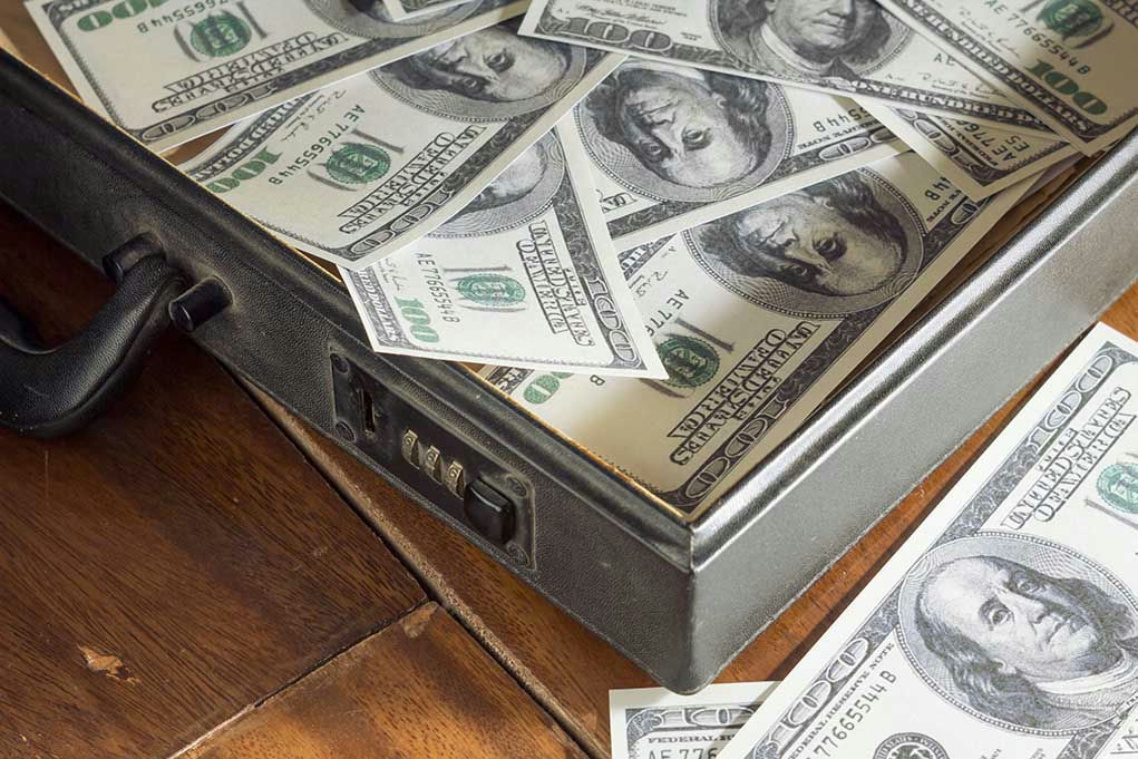 Open briefcase filled with one-hundred-dollar bills.