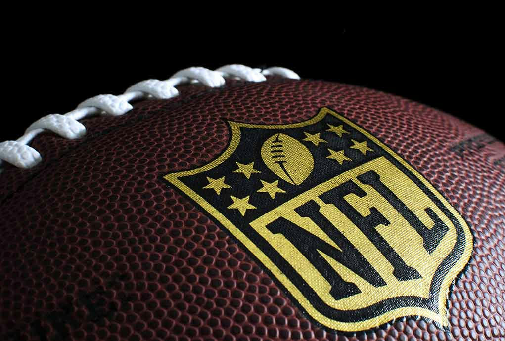 Close-up of football with NFL logo.