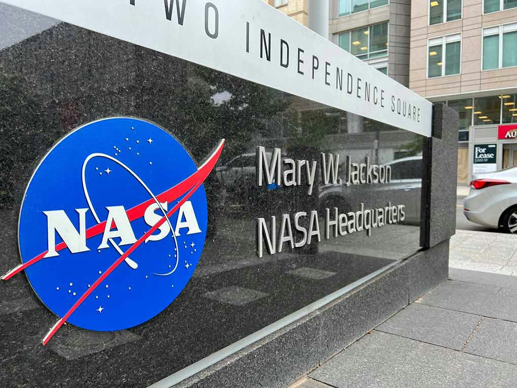 NASA Headquarters sign with logo and building in background.