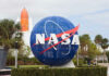 NASA globe sculpture with rocket in background.