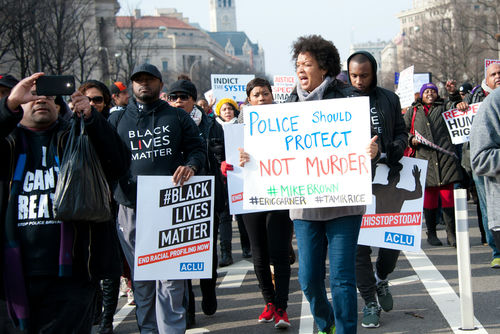 Protesters holding signs, including Police Should Protect Not Murder.