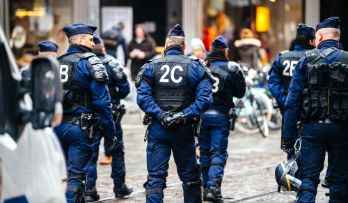 Police officers in uniform gather on a city street
