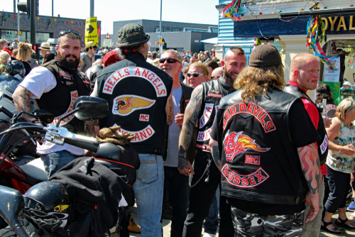 Group of bikers in leather vests at a crowded outdoor event