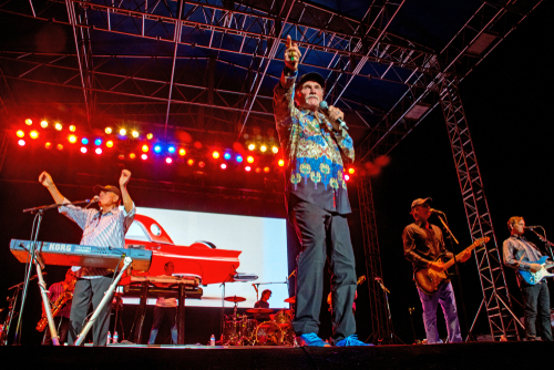 A band performing under colorful stage lights.