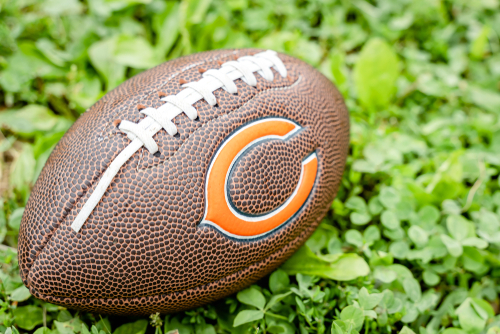 Football with Chicago Bears logo on grass.
