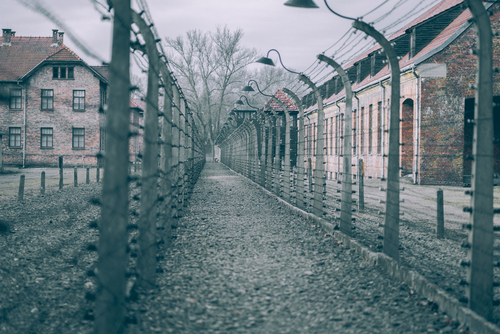 Auschwitz concentration camp fences and buildings in winter.
