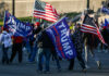 People holding Trump flags and American flags rallying
