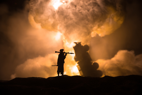 Soldier silhouette against explosion in dramatic battlefield scene.
