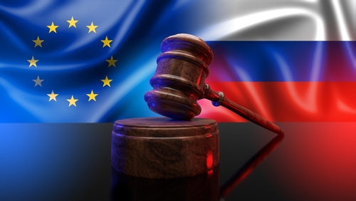 Gavel with EU and Russian flags in background.