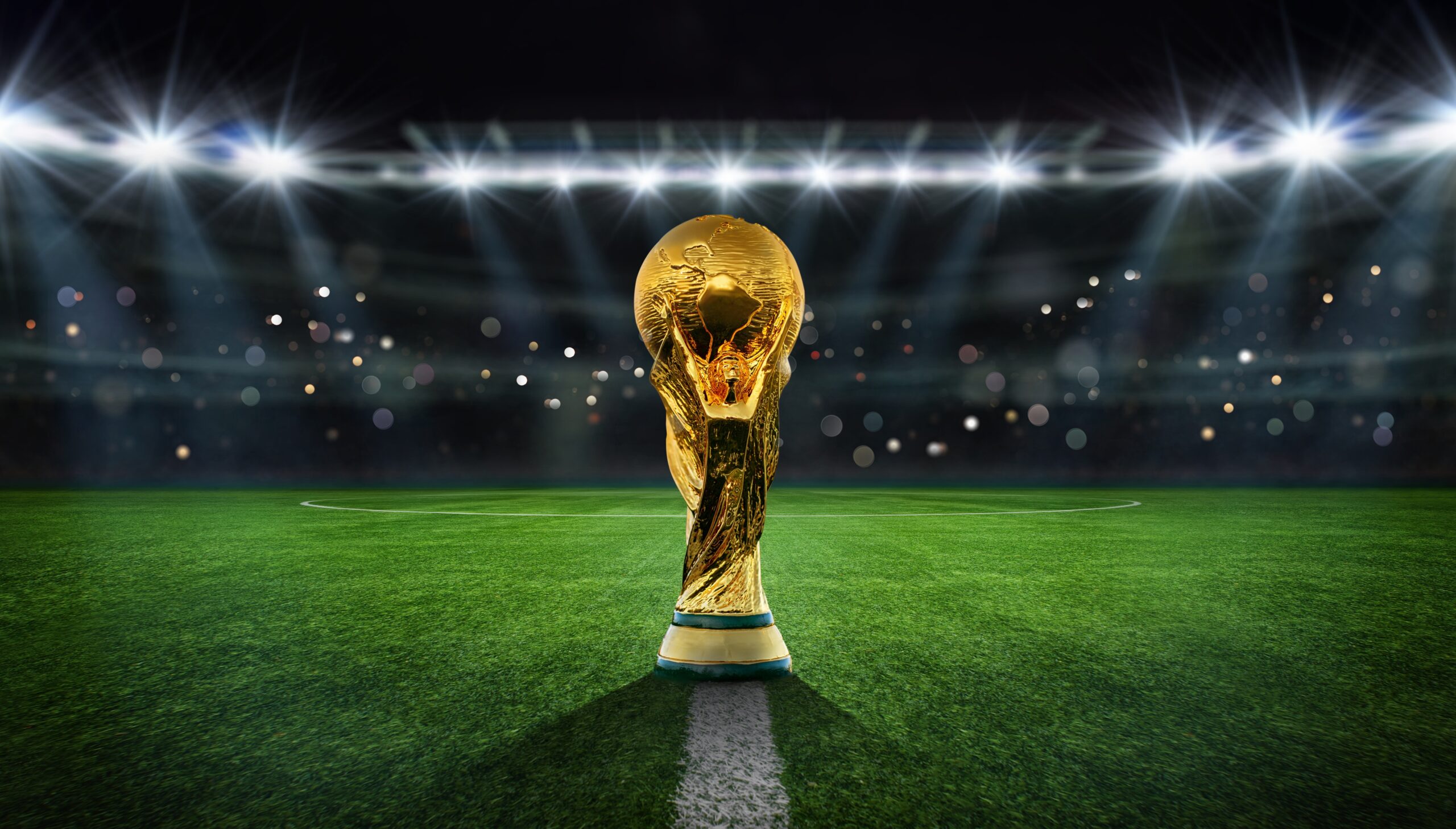 Golden trophy on soccer field under stadium lights