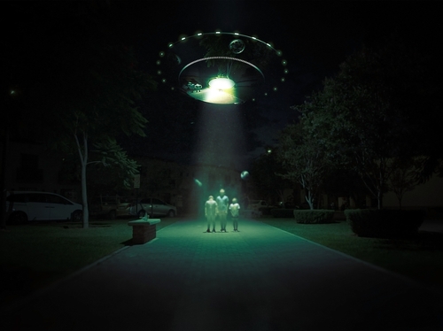Aliens being abducted by a UFO in a park.