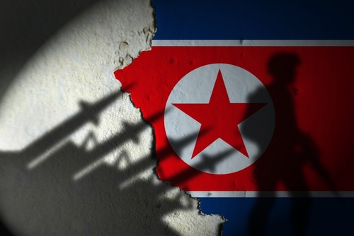 North Korean flag with soldier silhouette in shadow.