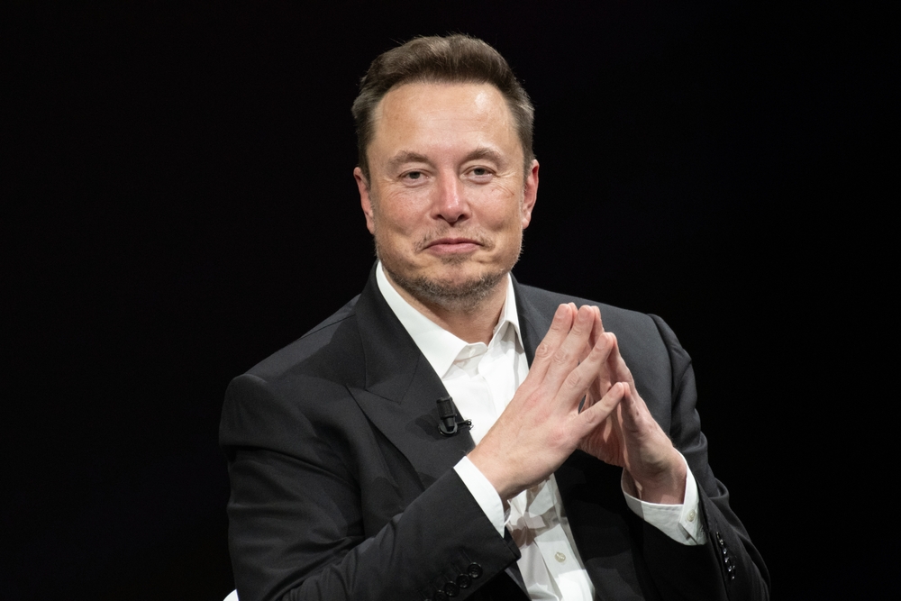 A person in a suit with hands clasped