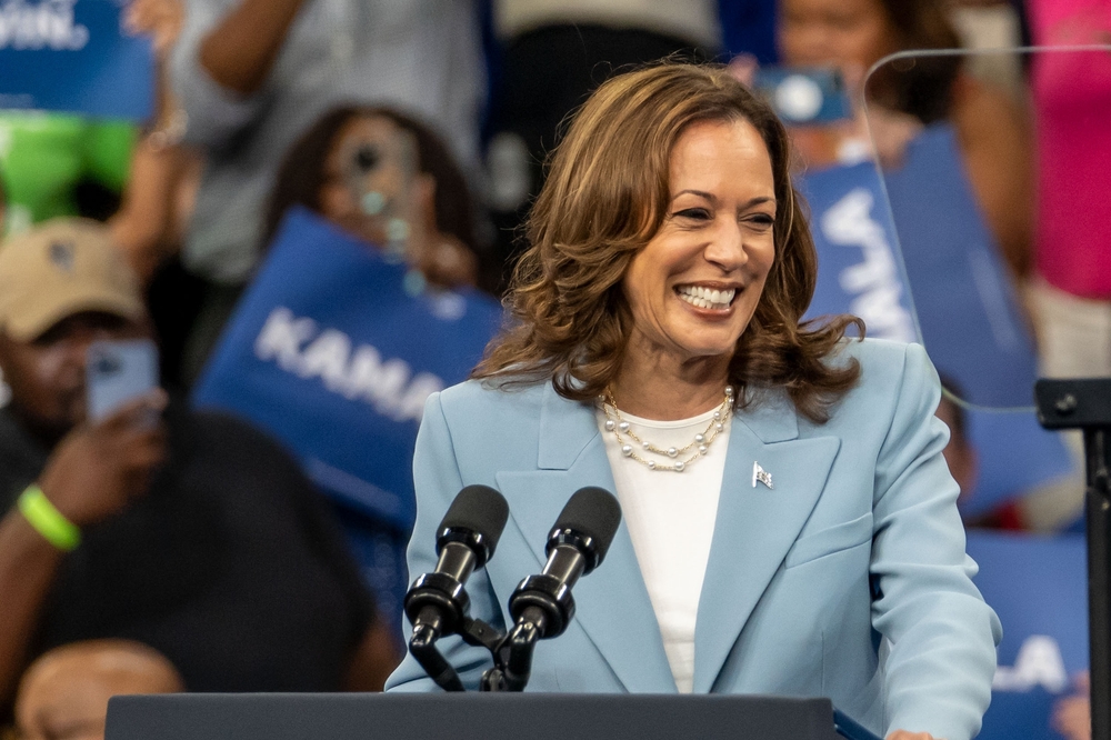 Smiling woman speaking at a crowded event indoors