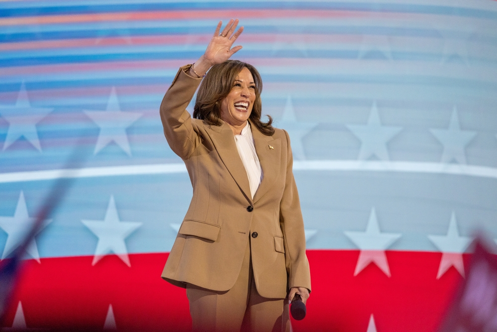 Woman waving in front of American flag backdrop