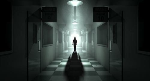 Silhouette in dimly lit hallway with room signs.