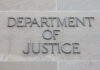 Sign reading 'Department of Justice' on a stone wall