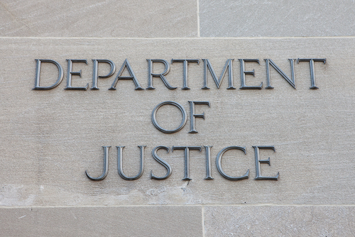 Sign reading 'Department of Justice' on a stone wall