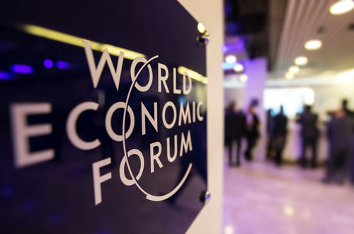 World Economic Forum sign with blurred people in background.