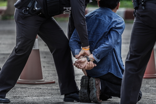 Police officers arresting a suspect in handcuffs